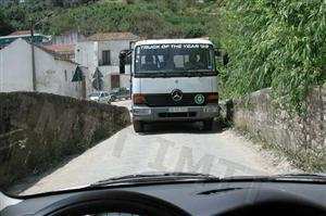 Nesta situação em que o veículo pesado está mais próximo do local em que o cruzamento é possível, devo: